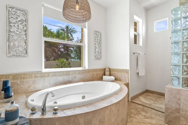 a living room with furniture a flat screen tv and floor to ceiling window