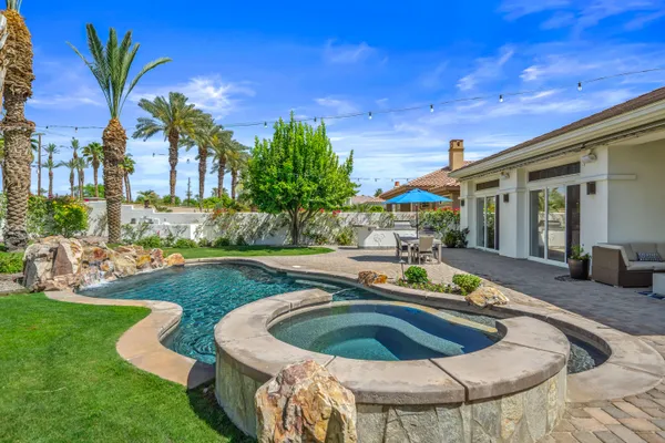 a view of a house with backyard sitting area and garden