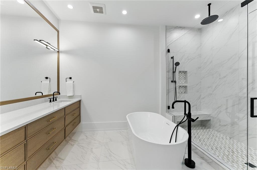 201 8th Street South, Unit 208 Naples, FL 34102 - Photo 17 of 39 Bathroom with marble finish flooring, a soaking tub, vanity, a marble finish shower, and recessed lighting