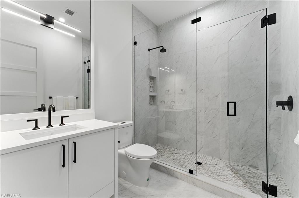 201 8th Street South, Unit 208 Naples, FL 34102 - Photo 22 of 39 Bathroom with marble finish flooring, vanity, and a marble finish shower