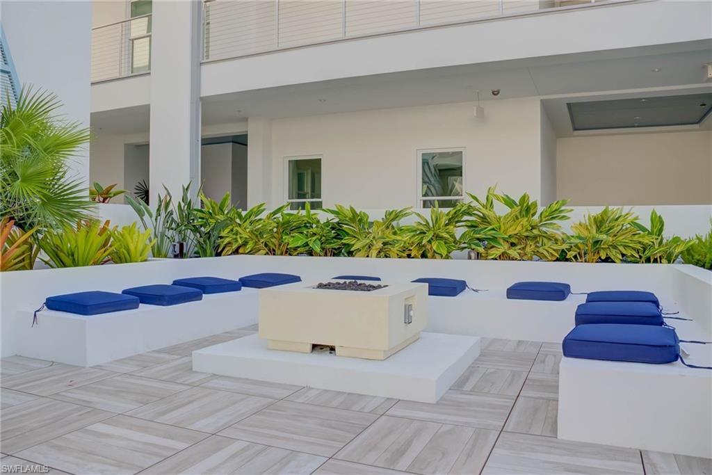 201 8th Street South, Unit 208 Naples, FL 34102 - Photo 27 of 39 Community pool and hot tub are next to the fire pit area with grilling area on the other side