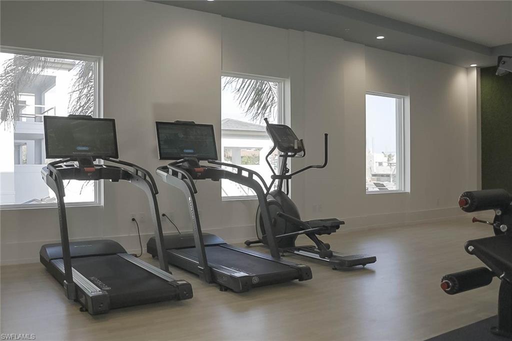201 8th Street South, Unit 208 Naples, FL 34102 - Photo 32 of 39 Workout area featuring wood finished floors, plenty of natural light, and recessed lighting