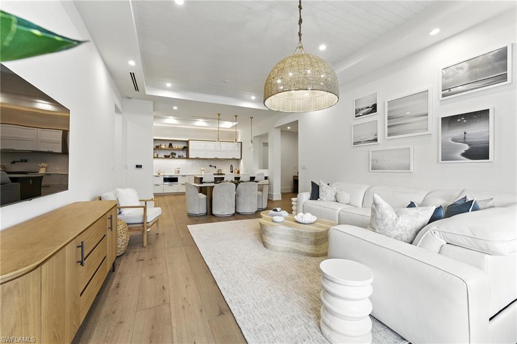 201 8th Street South, Unit 208 Naples, FL 34102 - Photo 7 of 39 Living room featuring recessed lighting, light wood-style flooring, and a tray ceiling