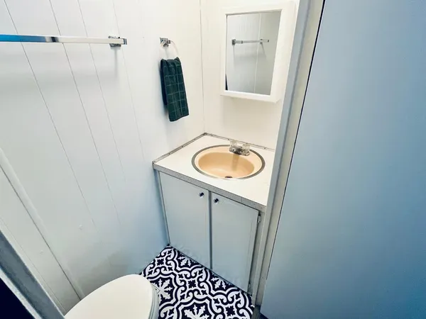 a bathroom with a sink a toilet a window and vanity