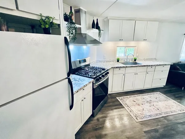 a kitchen with stainless steel appliances granite countertop a sink stove and refrigerator