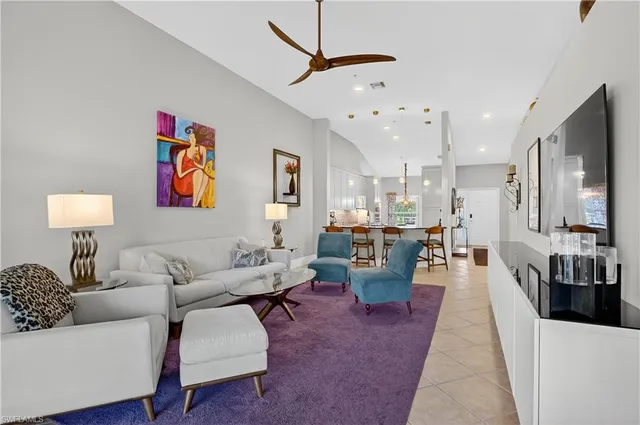a living room with furniture kitchen view and a window