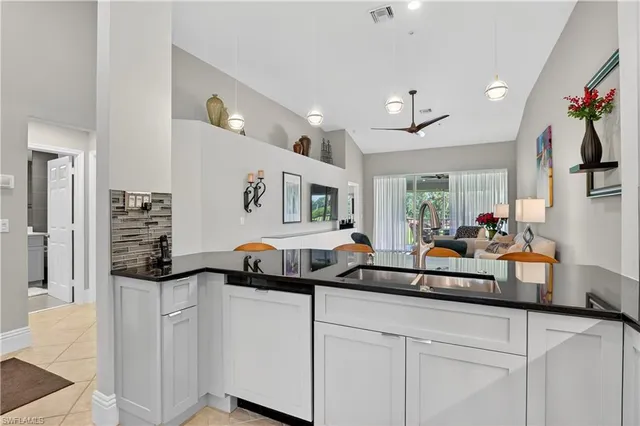 a large kitchen with granite countertop a sink and cabinets