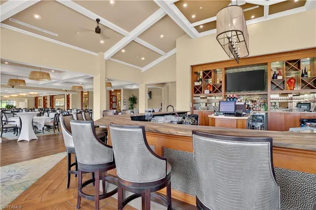 a dining hall with stainless steel appliances kitchen island granite countertop a table and chairs