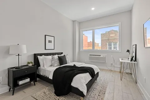 a bedroom with a bed and wooden floor