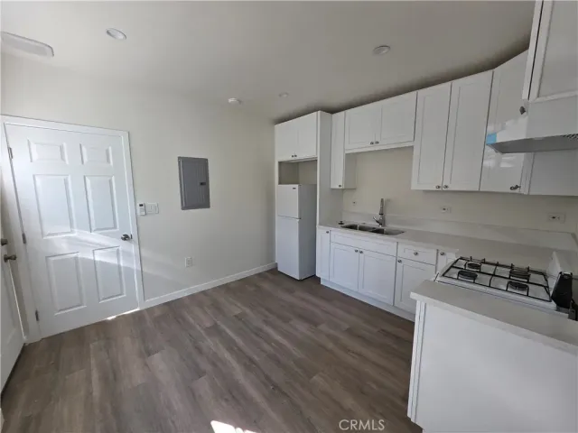 a kitchen with cabinets and wooden floor