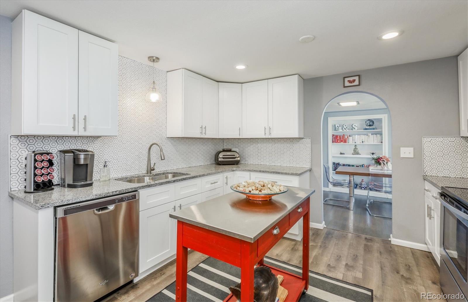 4115 Pierce Street Wheat Ridge, CO 80033 - Photo 8 of 21 a kitchen with stainless steel appliances granite countertop a stove top oven a sink dishwasher and cabinets with wooden floor