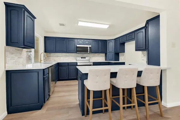 a kitchen with kitchen island granite countertop wooden cabinets and white stainless steel appliances