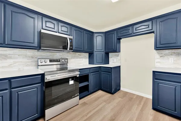 a kitchen with granite countertop wooden cabinets and stainless steel appliances