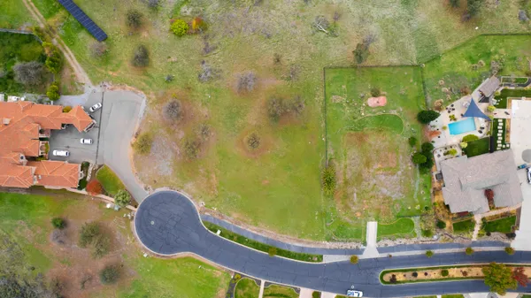 an aerial view of residential house with pool and yard