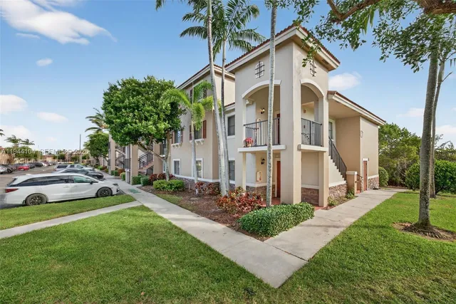 a front view of a house with a yard and potted plants