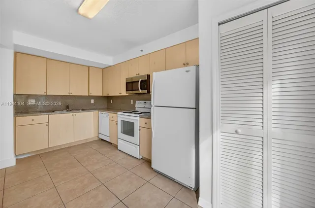 a kitchen with white cabinets and white appliances