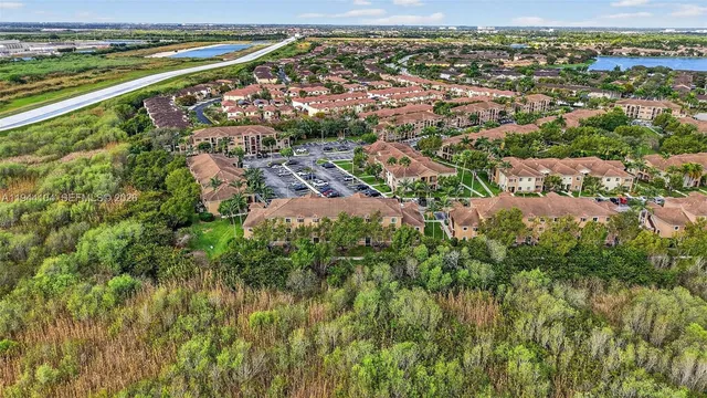 an aerial view of residential houses with outdoor space and trees