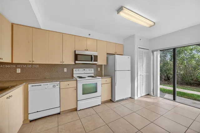 a kitchen with white cabinets and white appliances