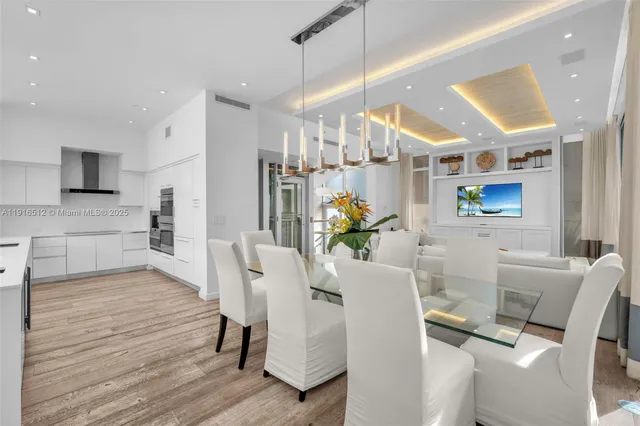 a dining room with furniture a chandelier and wooden floor