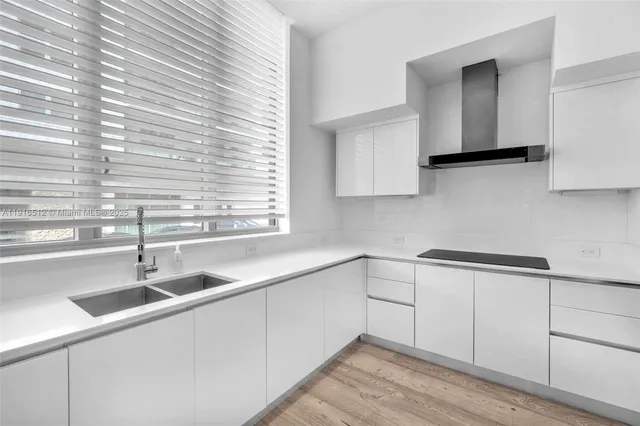 a kitchen with white cabinets and black appliances