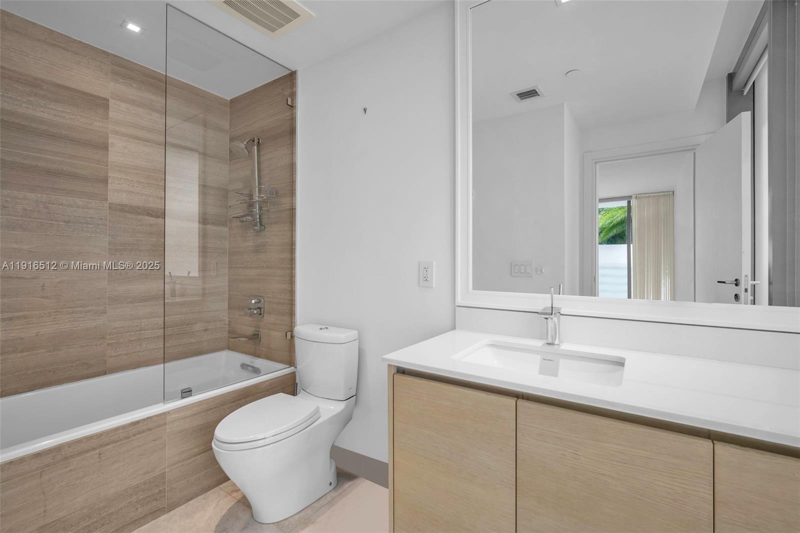 9501 Collins Avenue, Unit 1 Surfside, FL 33154 - Photo 27 of 53 a bathroom with a sink a toilet and shower