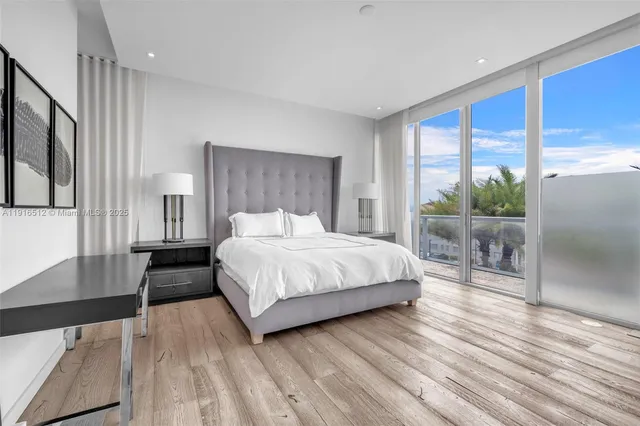 a bedroom with a bed and a flat tv screen on dresser