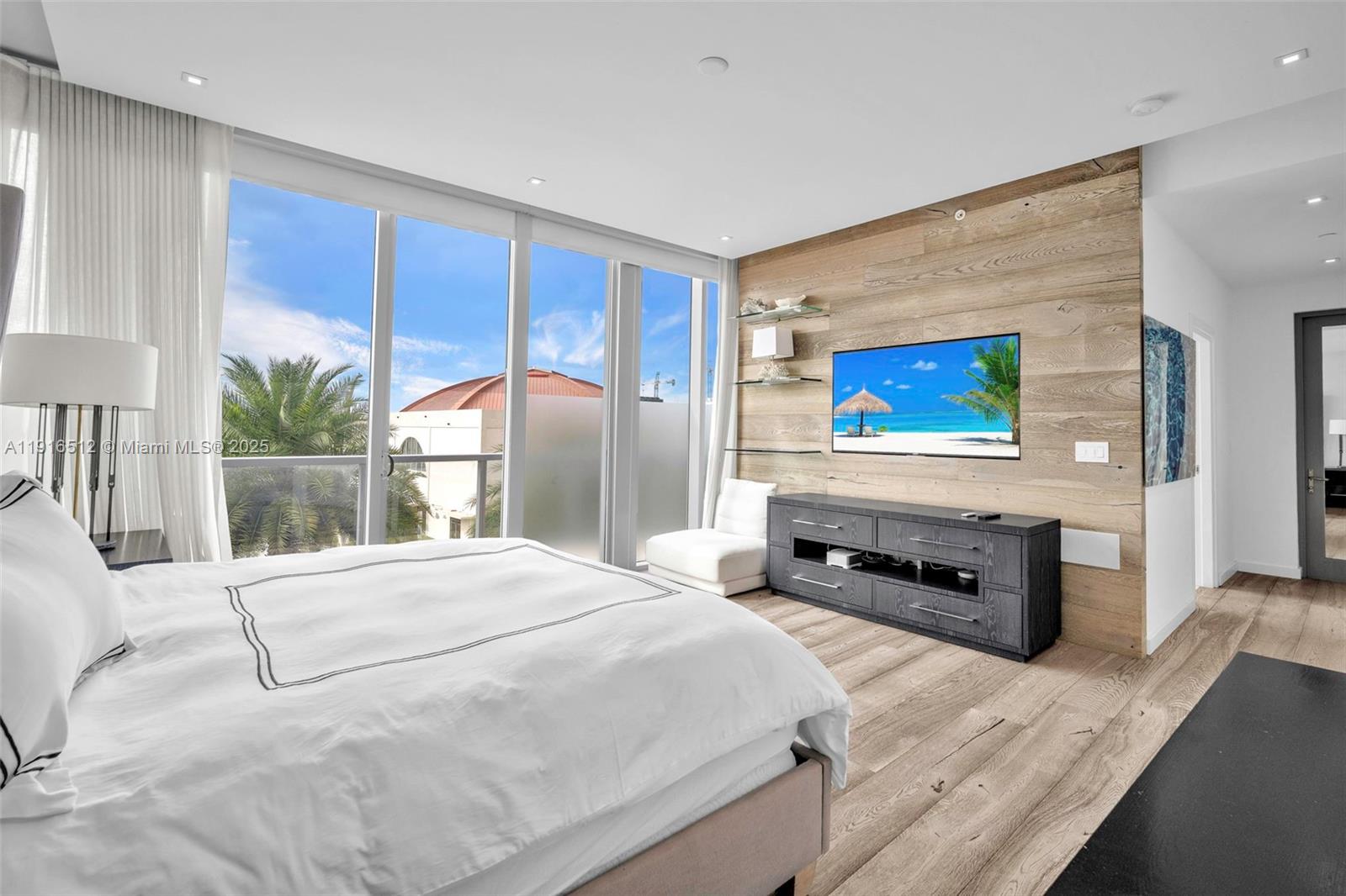 9501 Collins Avenue, Unit 1 Surfside, FL 33154 - Photo 33 of 53 a bedroom with a bed and a flat tv screen on dresser