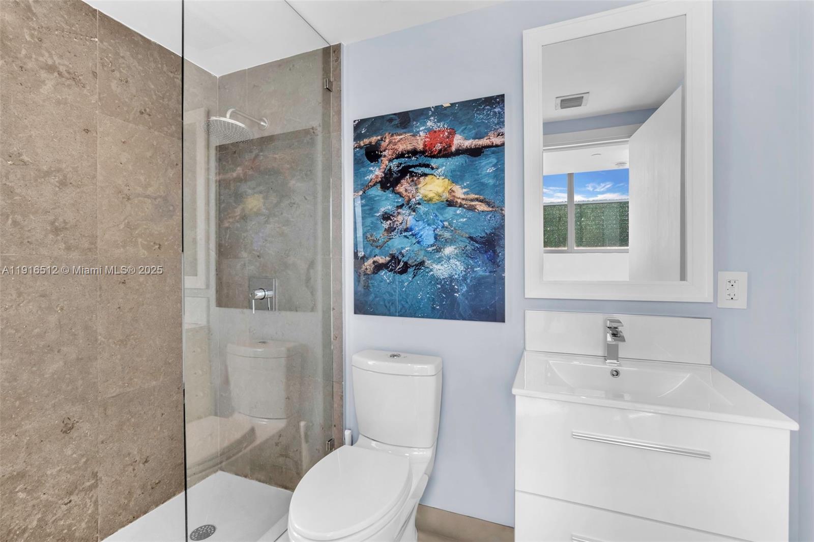 9501 Collins Avenue, Unit 1 Surfside, FL 33154 - Photo 42 of 53 a bathroom with a toilet sink and mirror