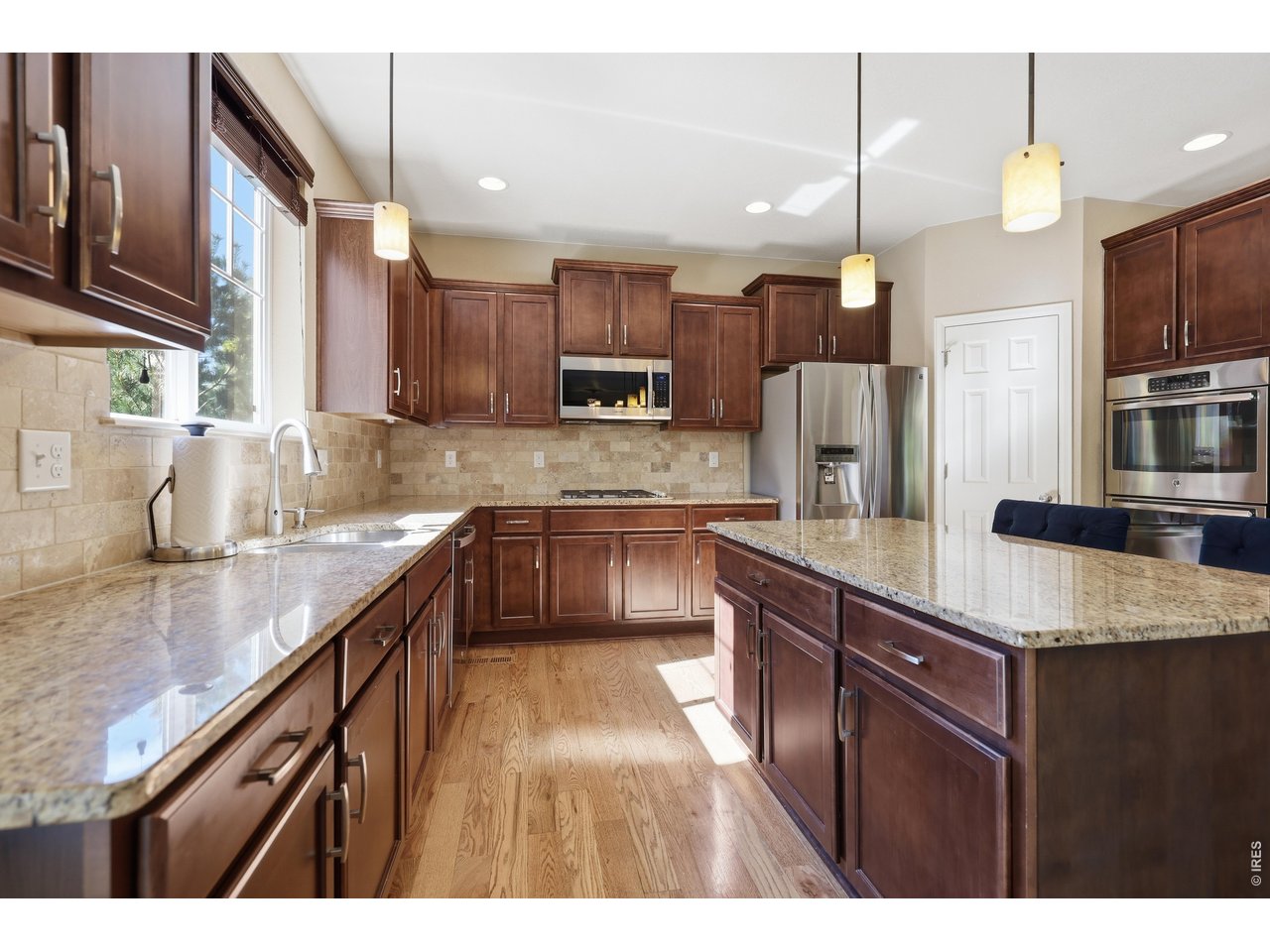 8709 Tack Street Frederick, CO 80504 - Photo 13 of 43 a kitchen with stainless steel appliances granite countertop a sink a stove and a refrigerator