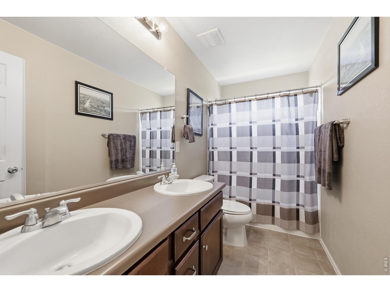 8709 Tack Street Frederick, CO 80504 - Photo 25 of 43 a bathroom with a double vanity sink toilet and shower