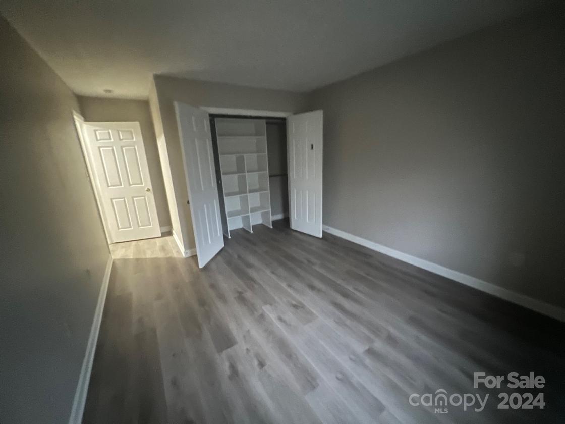 11714 Harrowfield Road Charlotte, NC 28226 - Photo 11 of 15 an empty room with wooden floor and windows
