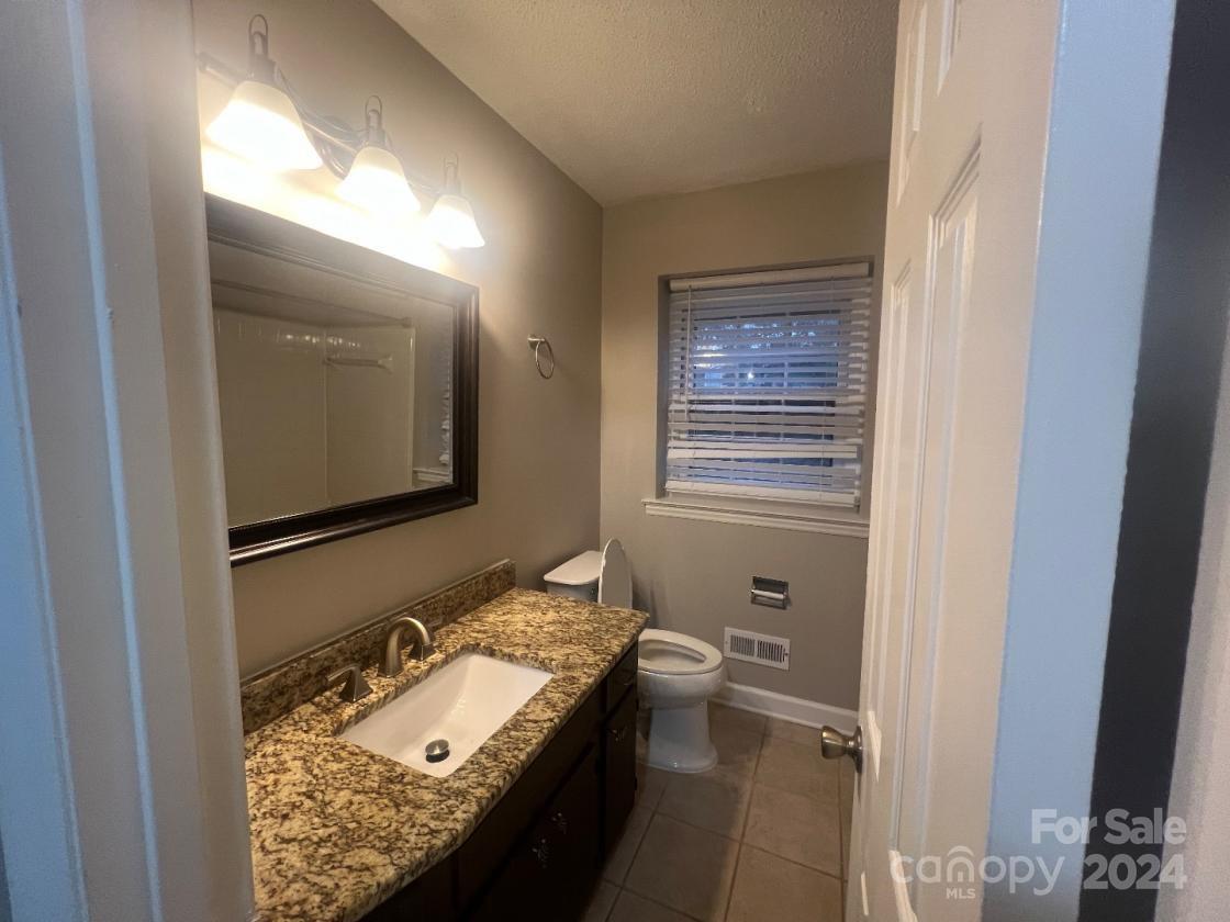 11714 Harrowfield Road Charlotte, NC 28226 - Photo 12 of 15 a bathroom with a granite countertop sink mirror and vanity