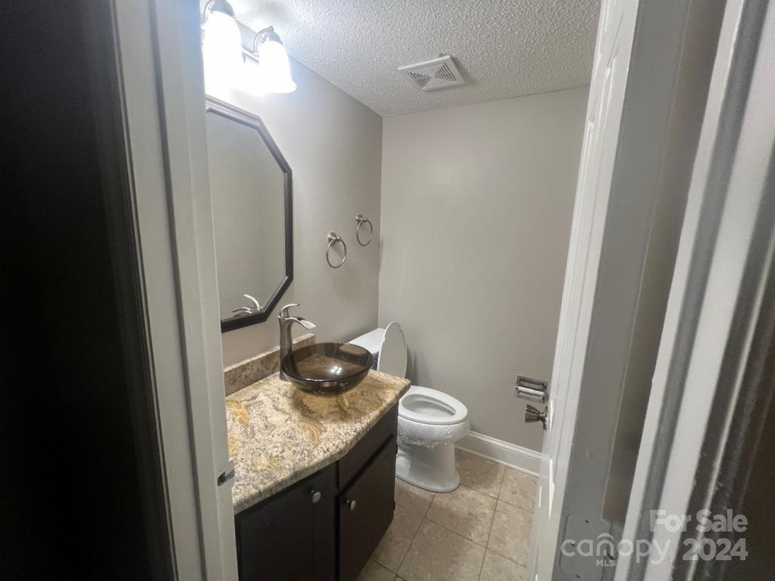 11714 Harrowfield Road Charlotte, NC 28226 - Photo 5 of 15 a bathroom with a granite countertop sink a toilet and a mirror