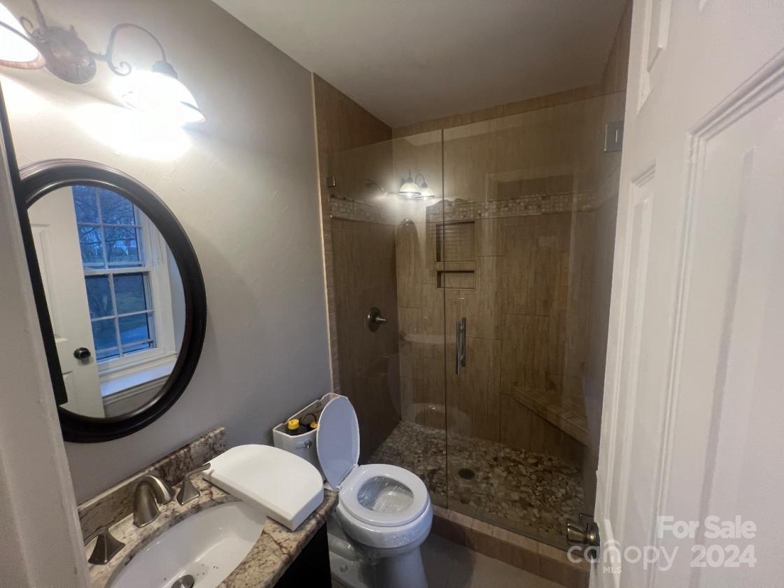 11714 Harrowfield Road Charlotte, NC 28226 - Photo 10 of 15 a bathroom with a toilet a sink and a mirror