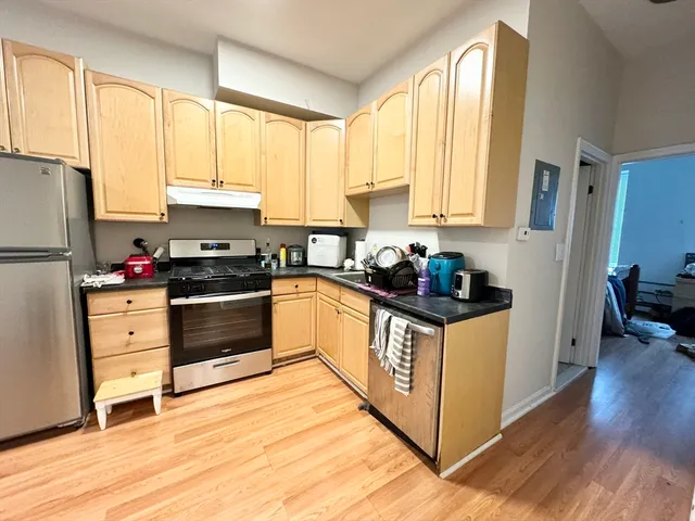 a kitchen with kitchen island granite countertop a stove a sink and white cabinets