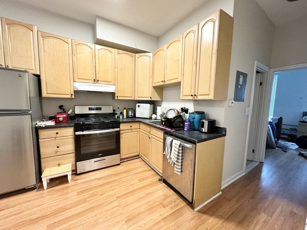96 Hammond Street, Unit 2 Boston, MA 02120 - Photo 1 of 7 a kitchen with kitchen island granite countertop a stove a sink and white cabinets