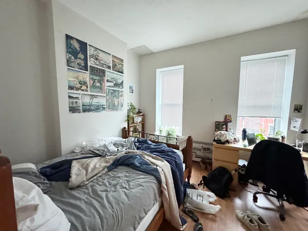 a bedroom with a bed a dresser and a window