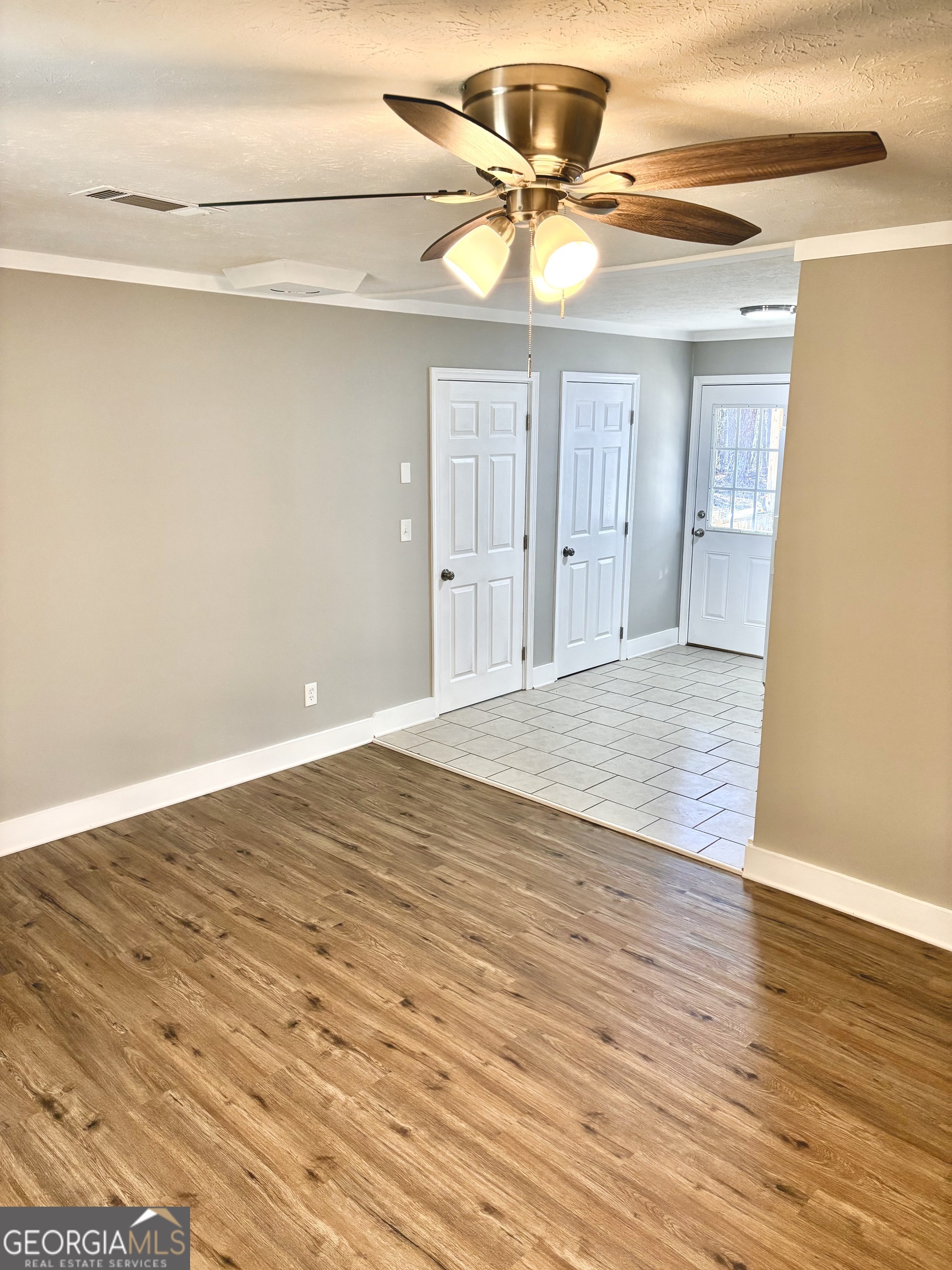 56 John Lovelace Road LaGrange, GA 30241 - Photo 11 of 26 a view of an empty room with wooden floor and a ceiling fan