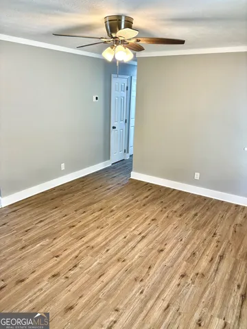 a view of an empty room with wooden floor