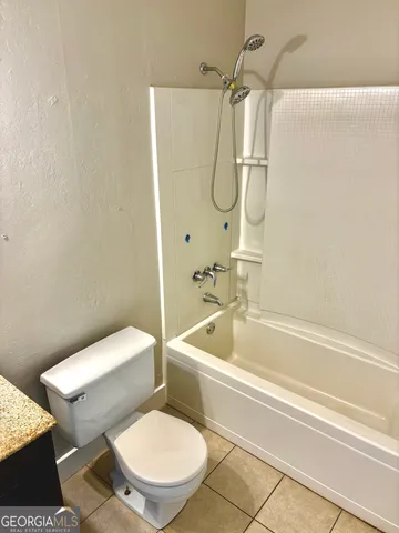 a white toilet sitting next to a bath tub and a shower