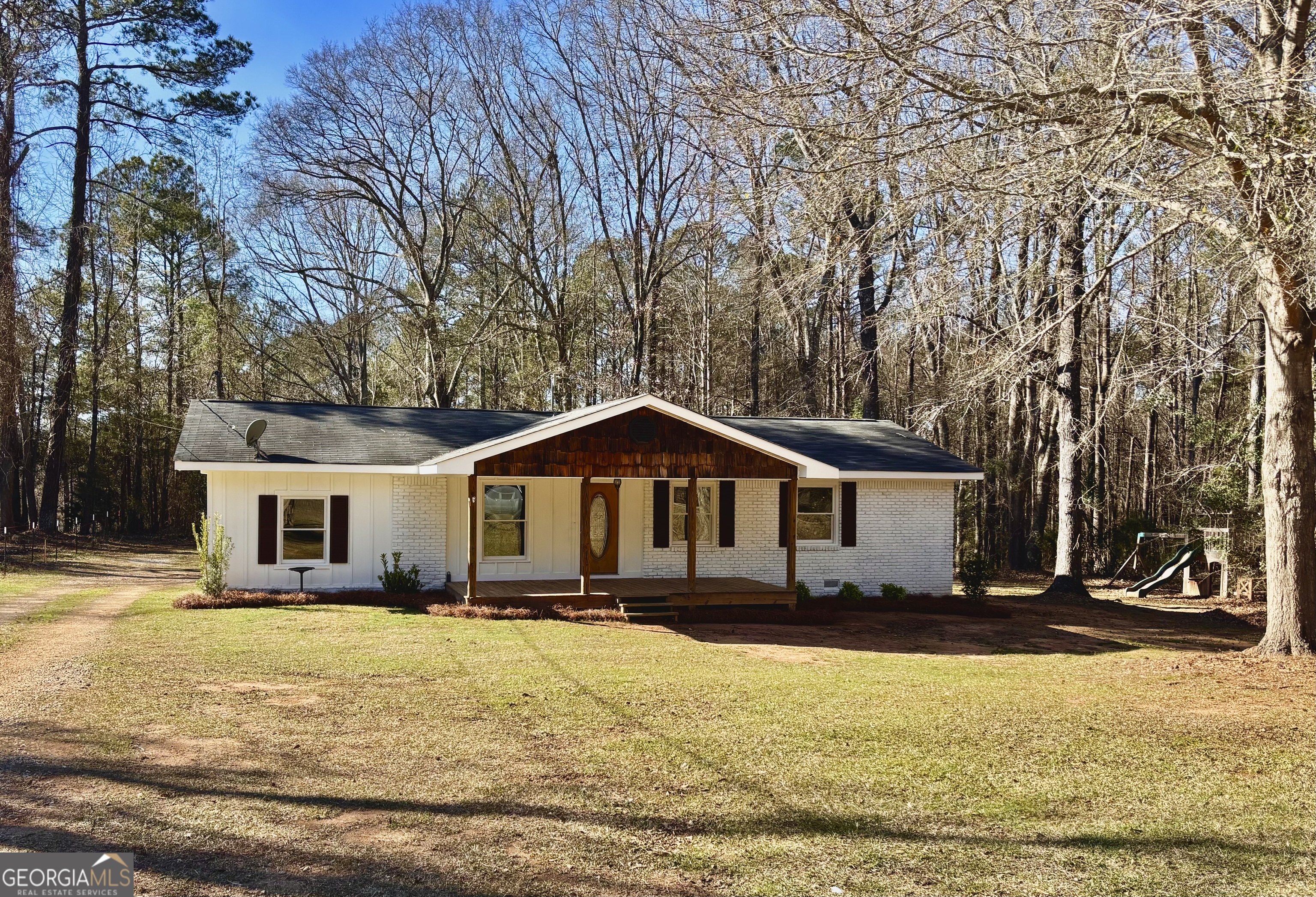 56 John Lovelace Road LaGrange, GA 30241 - Photo 3 of 26 a front view of a house with a yard covered with snow and trees
