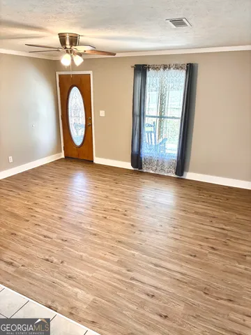 a view of a room with wooden floor and window