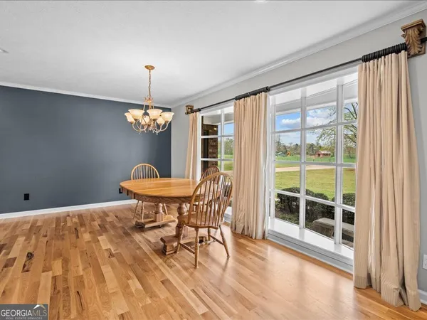 a dining room with furniture a chandelier and wooden floor