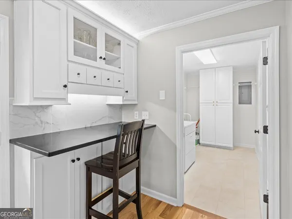 a view of kitchen with white cabinets and wooden floor