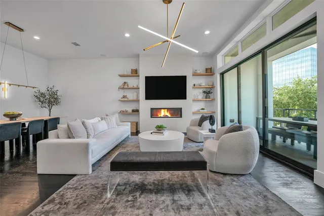 a living room with furniture a flat screen tv and a large window
