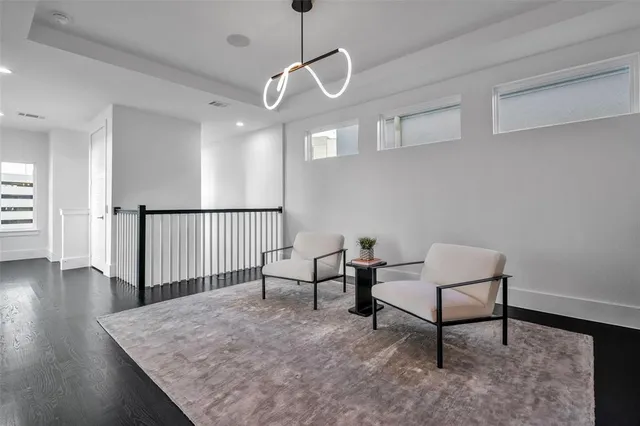 a view of a hallway with wooden floor and a chandelier