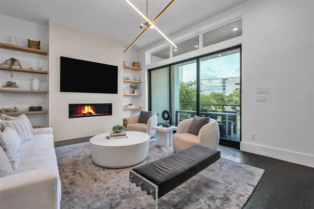 a living room with furniture a flat screen tv and a large window