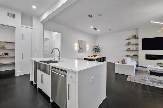 a kitchen with stainless steel appliances a sink stove and wooden floor