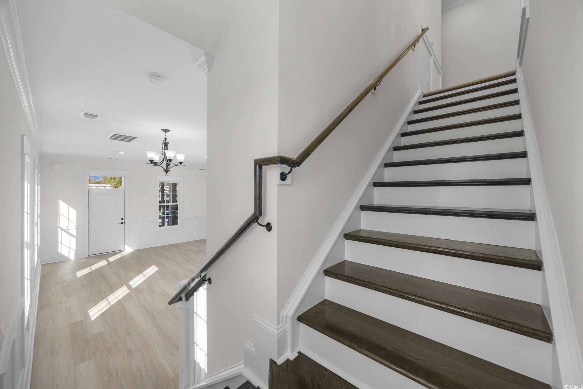 965 Hackler Street, Unit E Myrtle Beach, SC 29577 - Photo 16 of 36 Stairway with a chandelier and wood finished floors