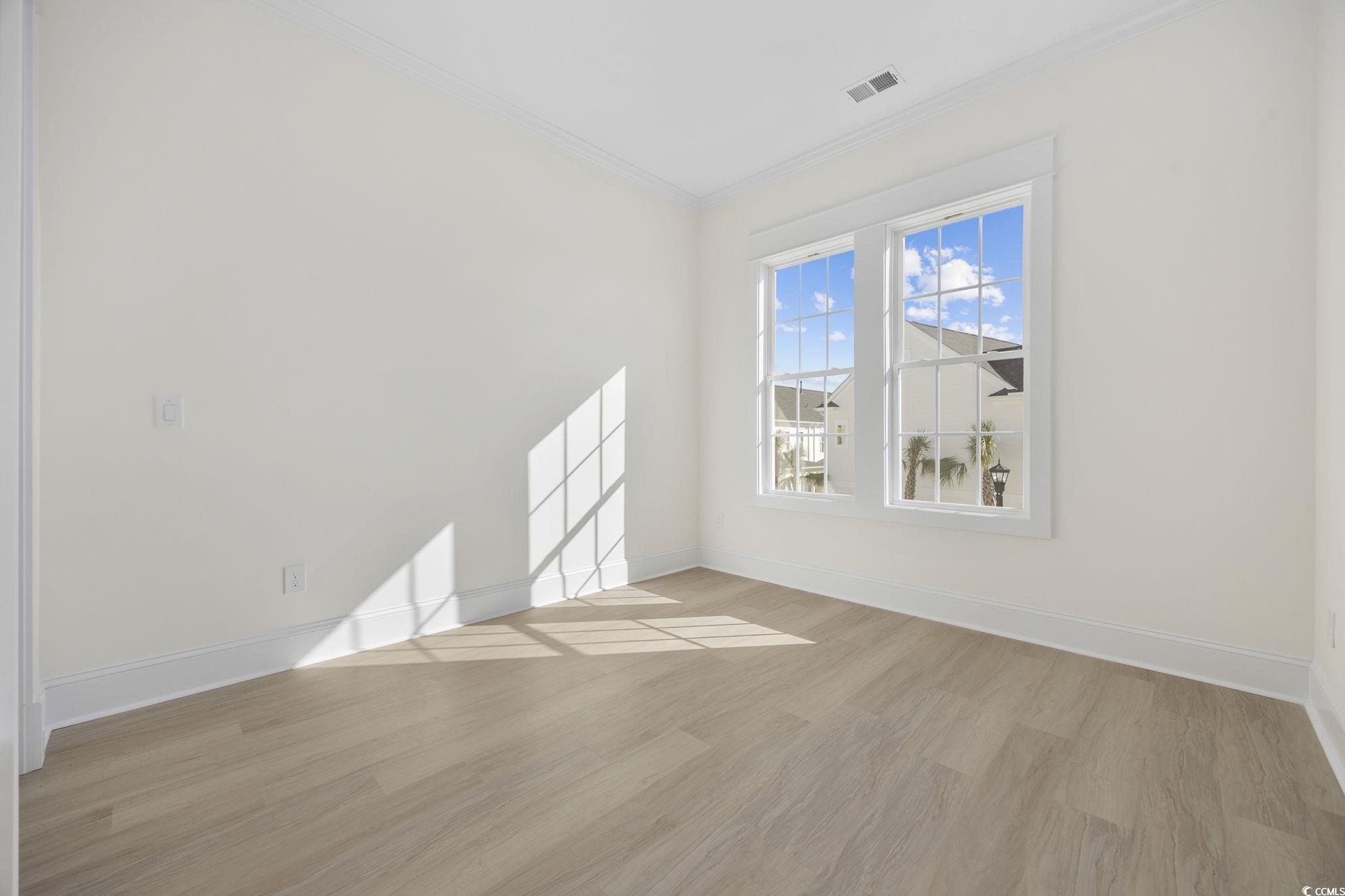 965 Hackler Street, Unit E Myrtle Beach, SC 29577 - Photo 19 of 36 Spare room with light wood-style floors and crown molding